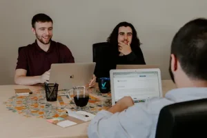 comunicación asertiva grupo de hombres hablando en mesa con portátiles