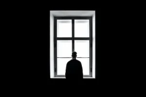 personas solitarias y hombre mirando por la ventana